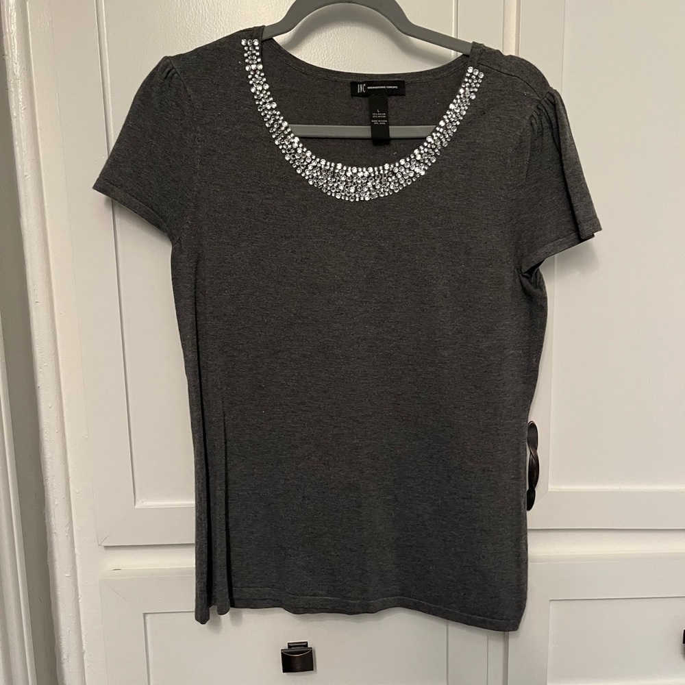 Charcoal gray sweater with jewel embellishment.